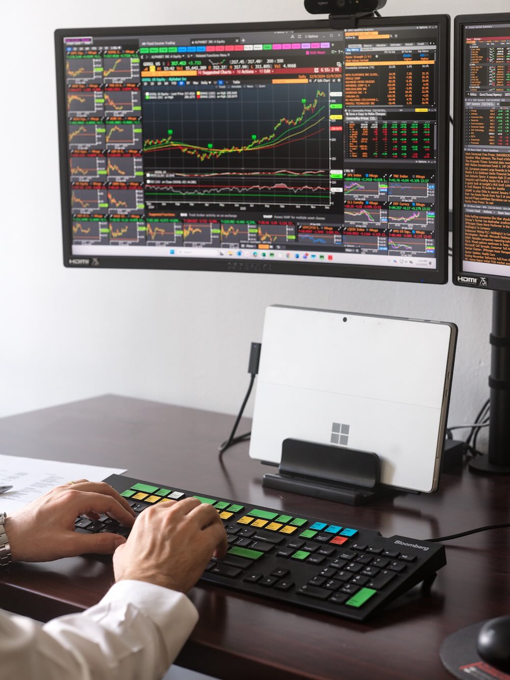 Close up of a desk with investment data displayed on a screen 